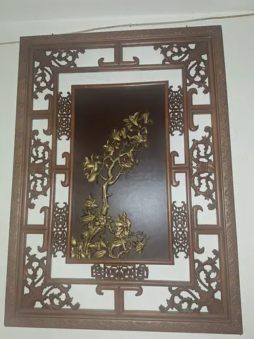 Vintage carved wooden wall panel with brass floral relief