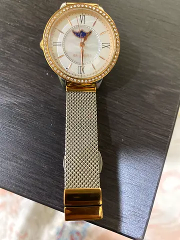 Gold-tone women's wristwatch with mesh band and moonphase dial