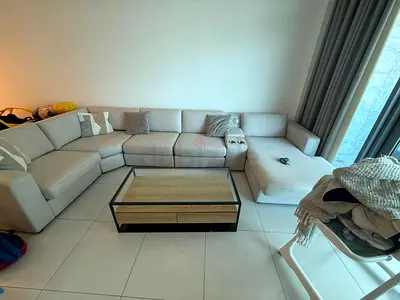 Large L-shaped beige fabric sectional sofa with chaise and coffee table