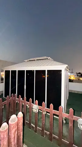White enclosed outdoor gazebo / sunroom - good condition with table and chairs.