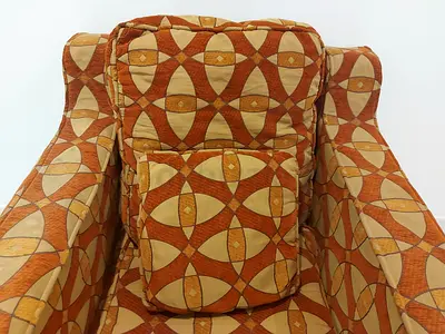 Single upholstered armchair with geometric orange pattern