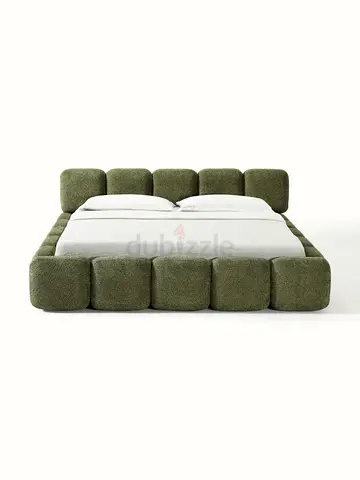 Low-profile green upholstered platform bed with padded block design