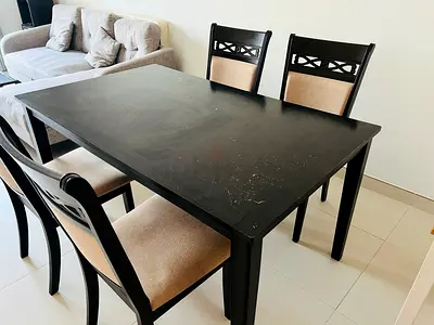 Solid black wooden dining table with 4 upholstered chairs - used