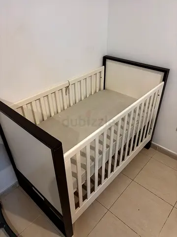 Giggles White and dark wood baby crib with mattress in good condition