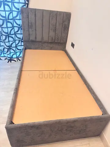 Pair of single bed frames (2) - grey upholstered bases, good condition . Single bed @ 300 AED .