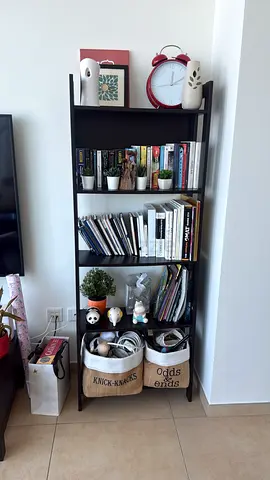 Used home bookshelf with mixed books and storage baskets