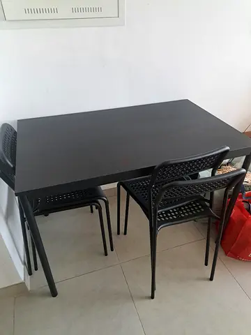 Modern black dining table with 4 stackable chairs - great condition. 110cm x 68cm x 76cm.