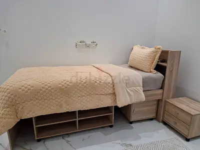 Single wooden bed with under-bed storage and matching bedside tables