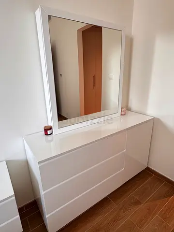 Dresser with a mirror and a green stool