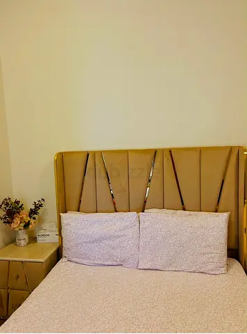 Gold upholstered king-size bed with padded headboard and matching 2 bedside tables.