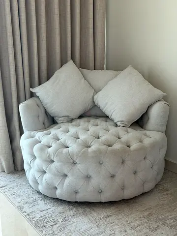 Light beige tufted round lounge chair with cushions with 360 degrees rotations