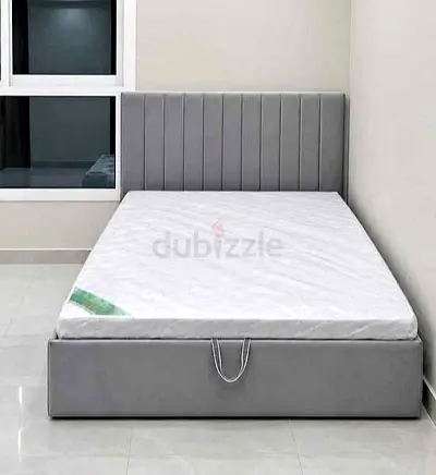 Grey upholstered double bed frame with mattress
