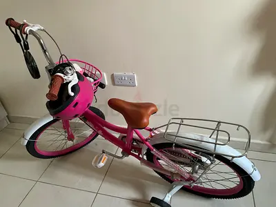 Pink kids' 20-inch bicycle with helmet and rear rack