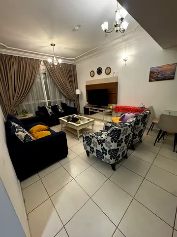 Navy blue sofa set with patterned armchairs and coffee table and round side table.