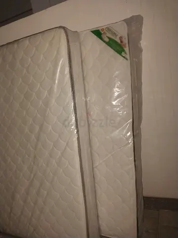 Two white queen size mattresses - new, plastic-covered, good quality