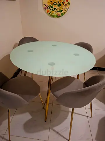 Round glass dining table with 4 grey velvet chairs, gold legs