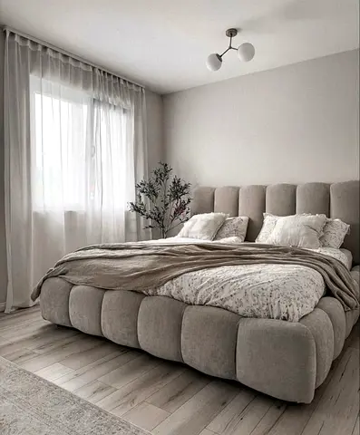 Plush upholstered king-size bed with padded headboard in beige