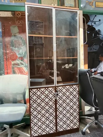 Wooden display cabinet with glass doors and patterned lower panels