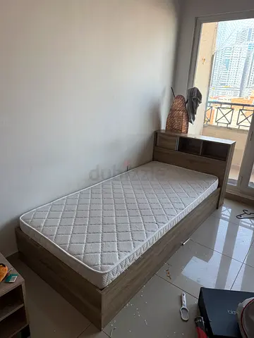 Single wooden bed frame with mattress and built-in headboard storage