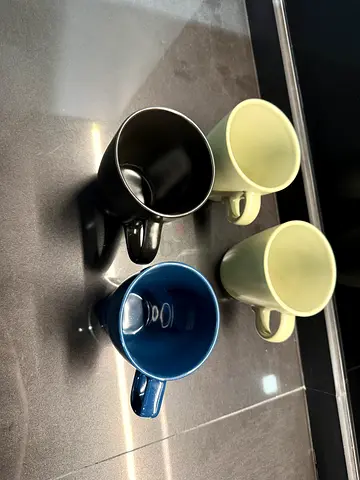 Set of 4 ceramic coffee mugs - mixed colors (cream, black, blue) - good condition