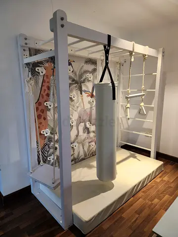 White wooden indoor / outdoor MonkeyBar - kids climbing gym with mattress and hanging equipment.