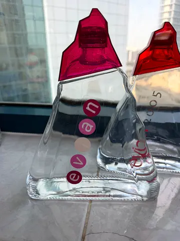 Two Evan perfumes — clear glass bottles with pink caps (used)