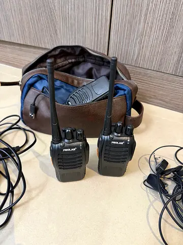 Pair of handheld walkie-talkie radios with chargers and bag