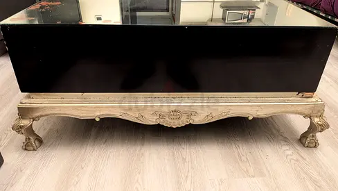 Vintage carved wood coffee table with black glass top
