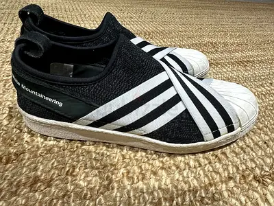 Black slip-on sneakers with white shell toe and elastic stripes - size unknown