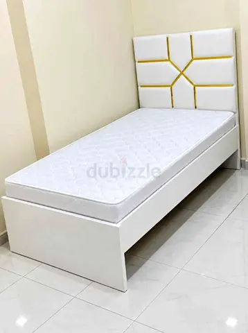 Single white bed frame with mattress and padded headboard