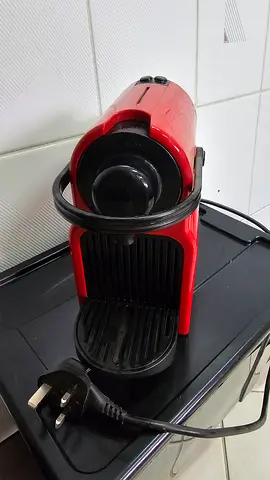 Compact red single-serve Nespresso-style coffee machine (used)
