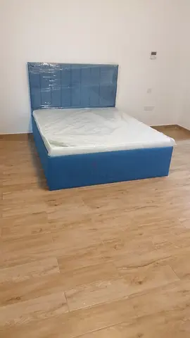 Blue upholstered double bed with headboard -