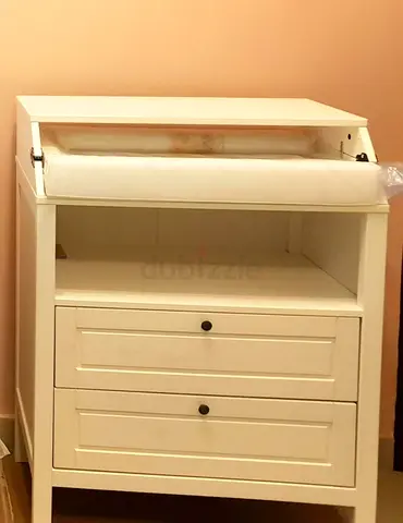 White wooden baby changing table with two drawers.