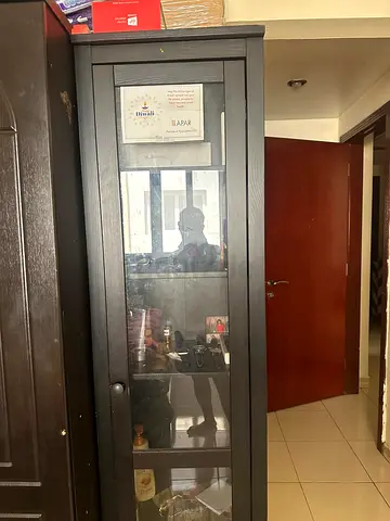 Tall black wooden display cabinet with glass door - good condition