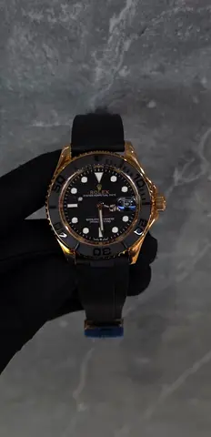 Rolex-style men's black dial sport watch with gold-tone case and rubber strap