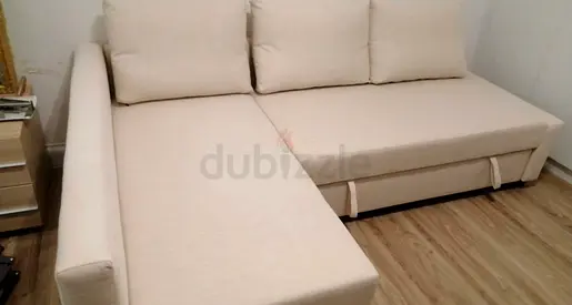 L-shaped beige fabric sofa bed with storage and pull-out bed