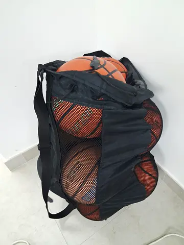 Used black mesh basketball carry bag with 11 basketballs