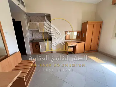 Spacious studio for rent in Al Butina, Sharjah. Features central air conditioning, central gas, built-in wardrobes, modern finishing, and an open view
