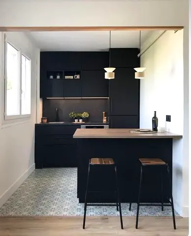Modern black fitted kitchen with breakfast bar and stools