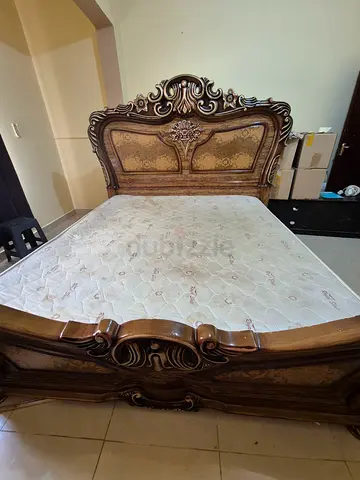 Ornate wooden double bed frame with mattress