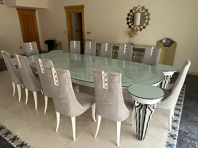 Large glass dining table with 12 upholstered chairs and joint side tables