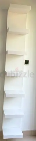 Tall white wall-mounted corner shelving unit — 6 floating shelves
