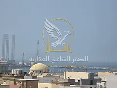 Spacious one-bedroom apartment with a living room in Al Qulai'a; features an open view and sandy par