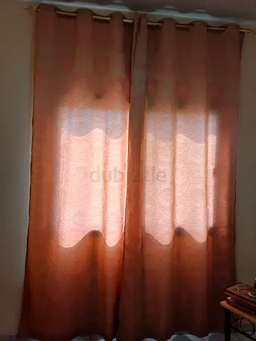 Pair of peach fabric eyelet curtains — good condition L: 180cm with curtain rod.