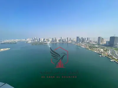 For rent in Al Majaz 3: A spacious 3-bedroom apartment with a living room and maid's room, featuring the best direct sea view, built-in wardrobes, par