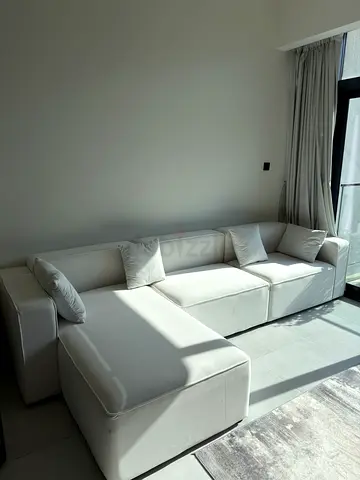Modern white L-shaped sectional sofa with cushions
