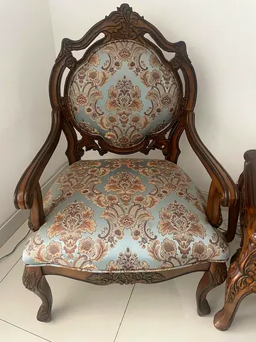 Vintage carved wooden armchair with patterned upholstery