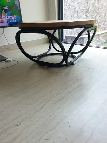Round wooden top coffee table with black metal base