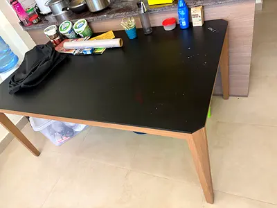Wooden dining table with black top — good condition