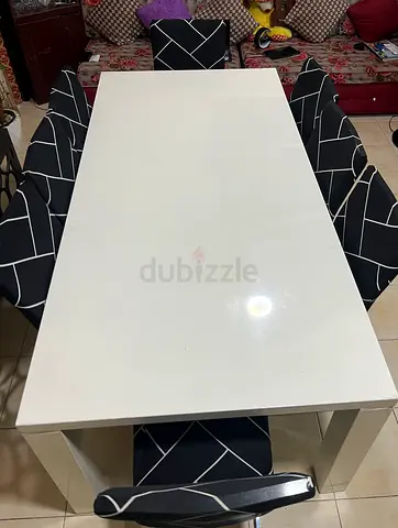 White dining table with 6 fabric-covered chairs - good used condition
